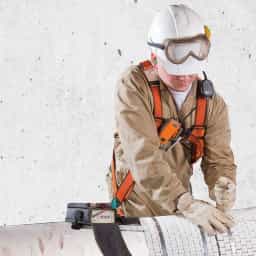 Field technician wrapping a pipe for industrial heat treatment